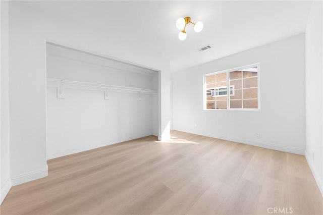 unfurnished bedroom with light wood-type flooring and a closet