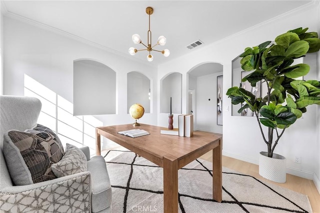 office space featuring light wood-type flooring, crown molding, and a notable chandelier