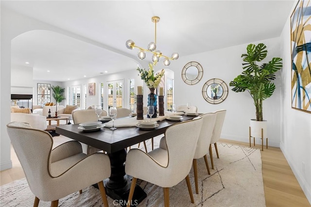 dining space with light hardwood / wood-style floors and a chandelier