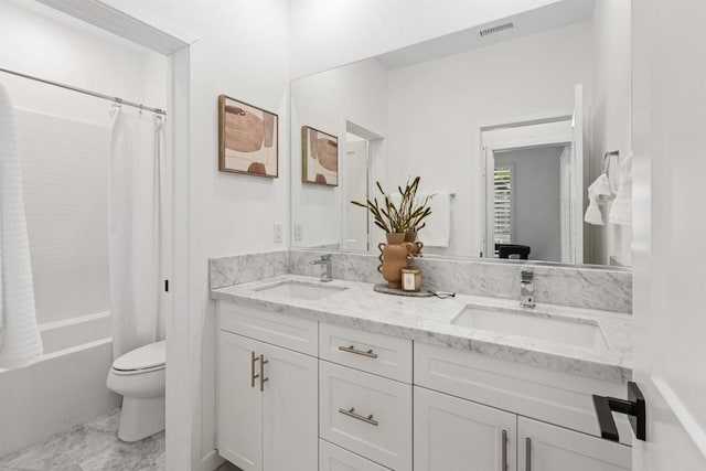 full bath featuring toilet, double vanity, visible vents, and a sink