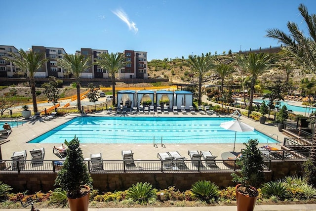 community pool with fence and a patio