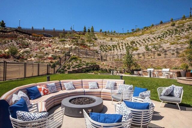 view of patio / terrace with an outdoor living space with a fire pit and fence