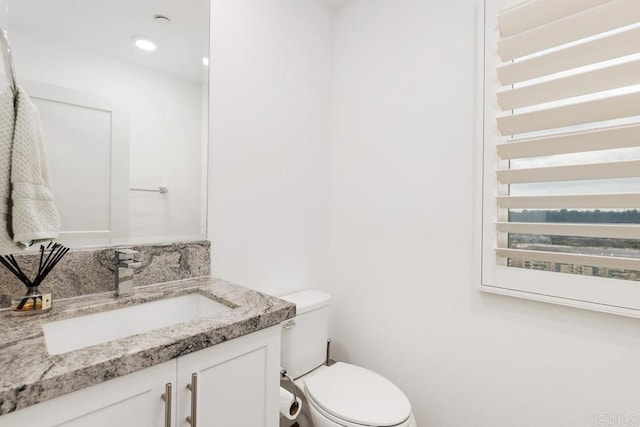 bathroom with toilet, recessed lighting, decorative backsplash, and vanity