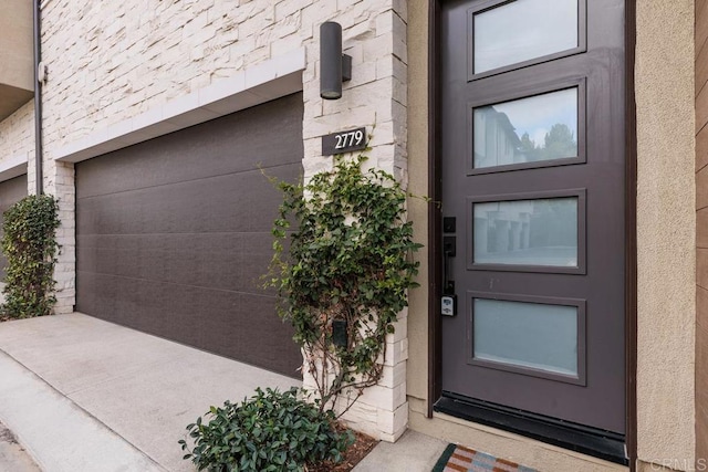 property entrance with a garage and stucco siding