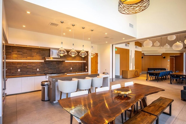 dining space with recessed lighting, visible vents, a towering ceiling, and light tile patterned floors