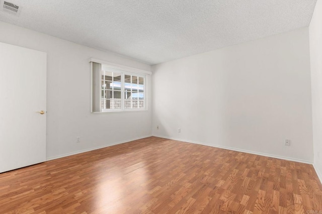 empty room featuring light hardwood / wood-style floors and a textured ceiling