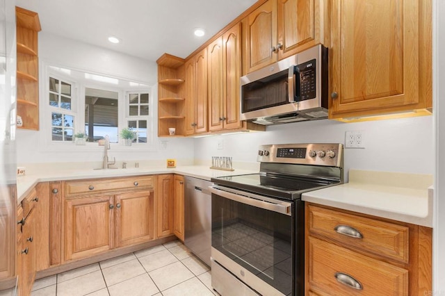 kitchen featuring stainless steel appliances, sink, and light tile patterned floors