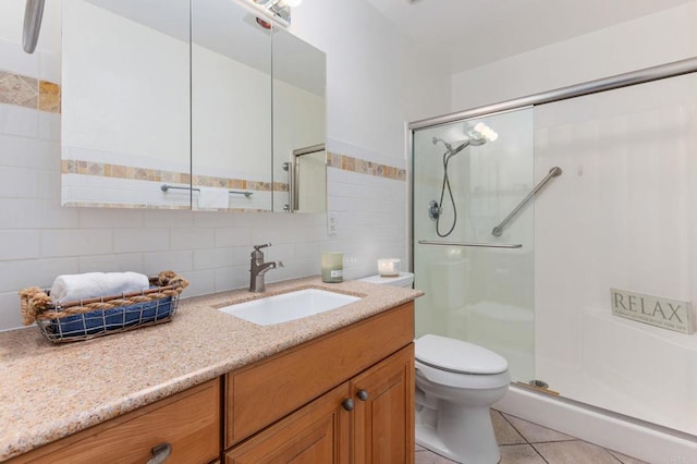 bathroom featuring vanity, decorative backsplash, a shower with shower door, tile patterned floors, and toilet