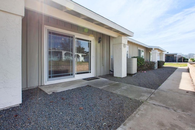 property entrance with cooling unit and a patio