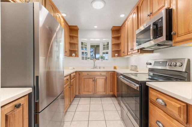 kitchen with appliances with stainless steel finishes, sink, and light tile patterned floors