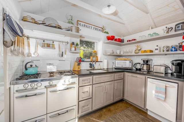 kitchen with backsplash, lofted ceiling with beams, sink, and range with two ovens