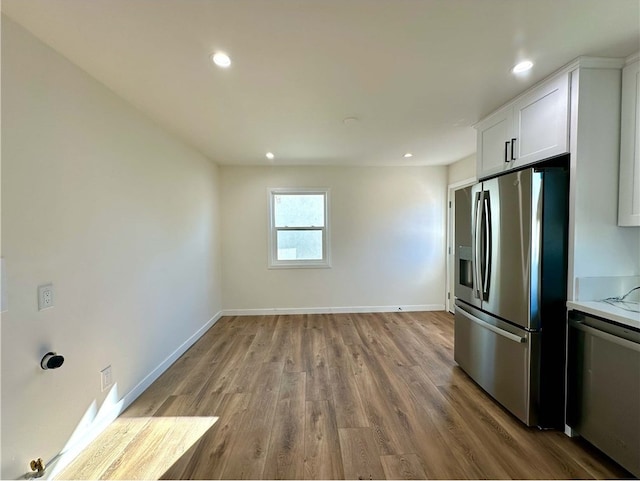 kitchen featuring stainless steel appliances, white cabinetry, and light wood-type flooring