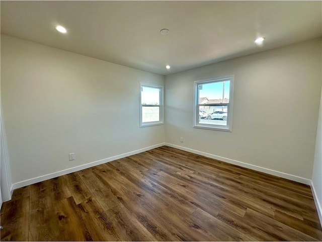 unfurnished room with dark wood-type flooring