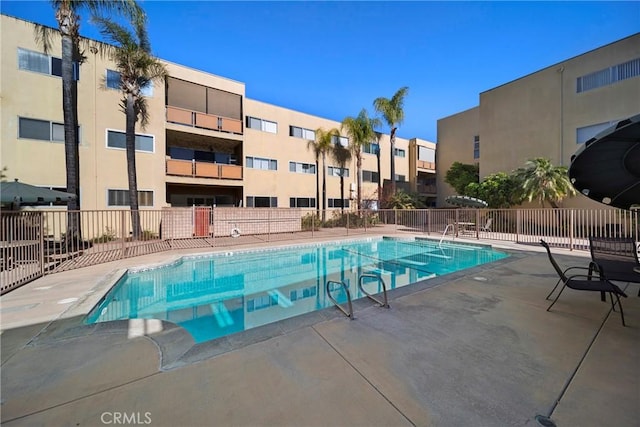 community pool featuring fence and a patio