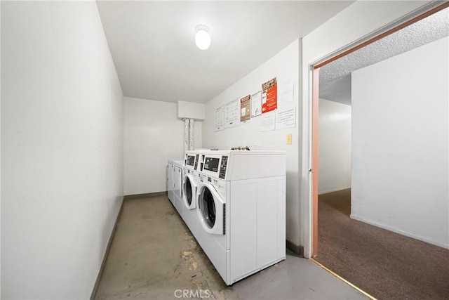 community laundry room with washing machine and dryer and baseboards