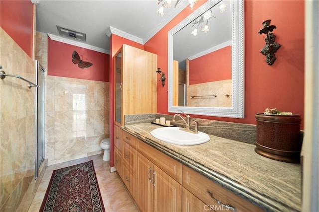 bathroom with crown molding, tile walls, toilet, a stall shower, and vanity