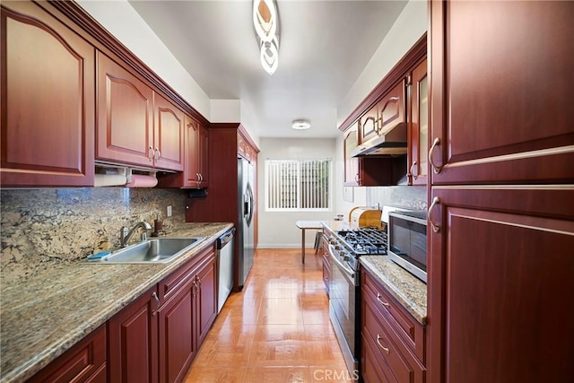 kitchen with dark brown cabinets, appliances with stainless steel finishes, and a sink