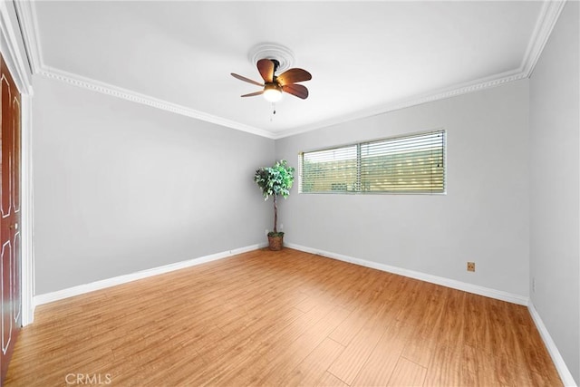 spare room with ceiling fan, crown molding, light wood-style flooring, and baseboards