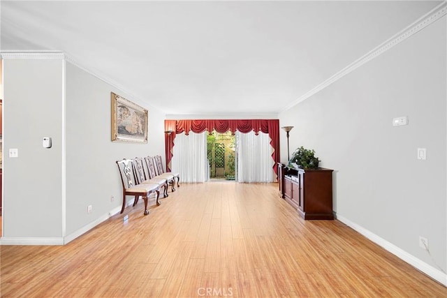 sitting room with light wood-type flooring, baseboards, and ornamental molding