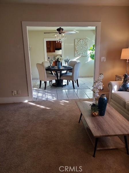 carpeted dining area with ceiling fan