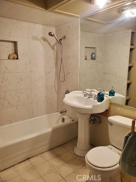 bathroom featuring toilet, tile patterned floors, and tub / shower combination