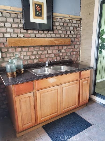 bar with sink and light tile patterned flooring