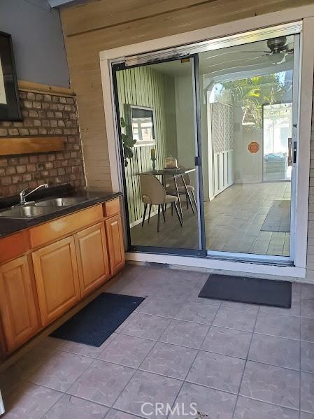 doorway featuring light tile patterned floors and sink