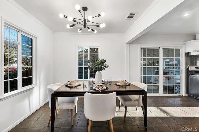 tiled dining space featuring ornamental molding and an inviting chandelier