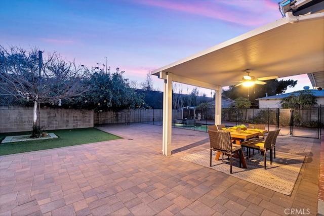 patio terrace at dusk featuring ceiling fan