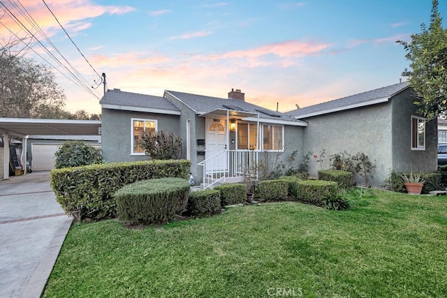 single story home with a yard, a garage, and a carport