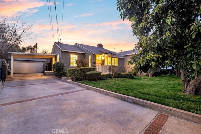 ranch-style home with a garage and a lawn