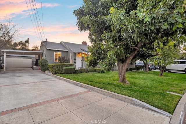 view of front of property featuring a garage and a lawn