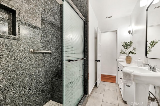 bathroom with tile patterned floors, a shower with door, and sink