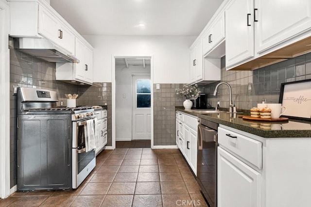 kitchen with dark tile patterned flooring, stainless steel gas stove, dishwasher, and white cabinetry