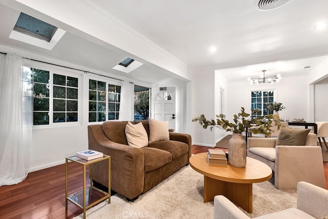 living room featuring hardwood / wood-style floors, an inviting chandelier, and crown molding