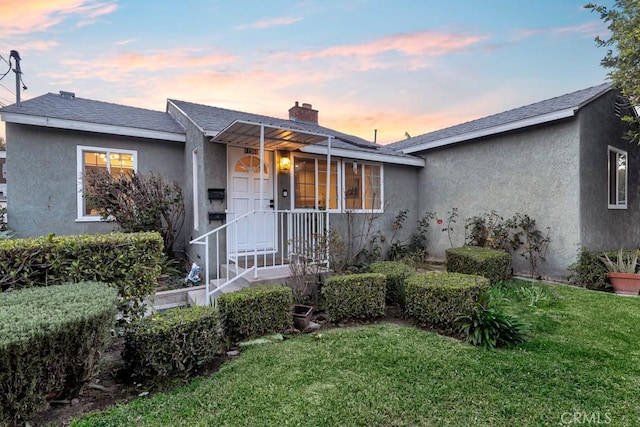 ranch-style home featuring a lawn