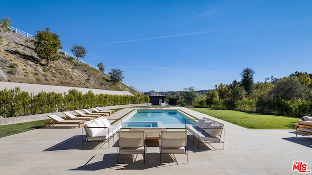 view of pool with a yard and a patio