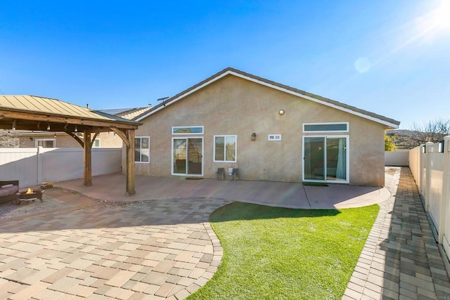 back of property featuring a gazebo and a patio area