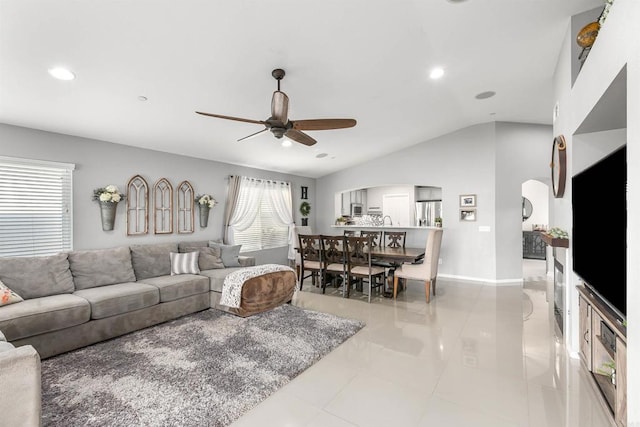 living room featuring ceiling fan, light tile patterned flooring, and vaulted ceiling