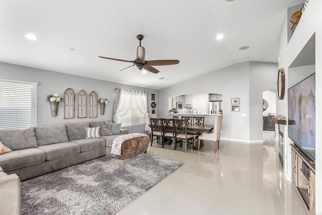 living room featuring ceiling fan, light tile patterned floors, and vaulted ceiling