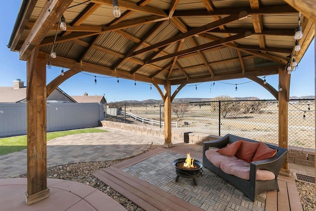 view of patio with a gazebo and an outdoor living space with a fire pit