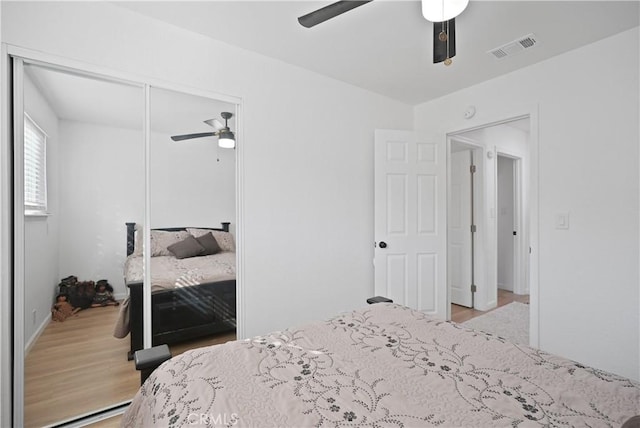 bedroom with ceiling fan, light wood-type flooring, and a closet