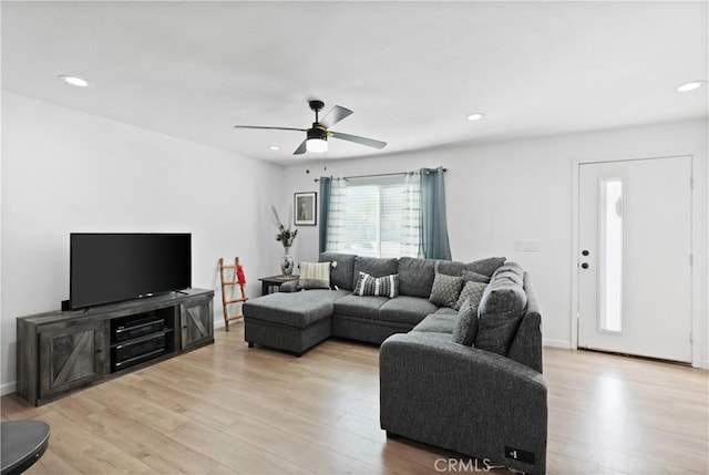 living room featuring light hardwood / wood-style floors and ceiling fan