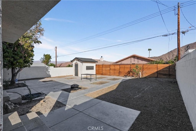 view of yard featuring a fire pit, a shed, and a patio