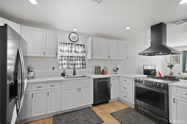 kitchen featuring white cabinets, sink, light hardwood / wood-style floors, appliances with stainless steel finishes, and island range hood