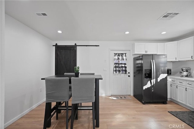 dining room featuring a barn door and light hardwood / wood-style flooring