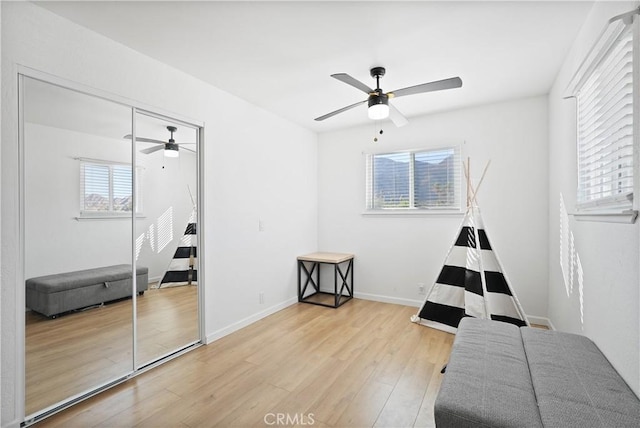 bedroom with ceiling fan, a closet, and light wood-type flooring