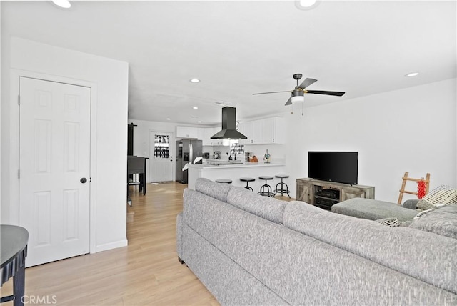 living room featuring ceiling fan and light wood-type flooring