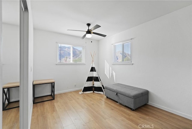 living area featuring ceiling fan and light hardwood / wood-style floors