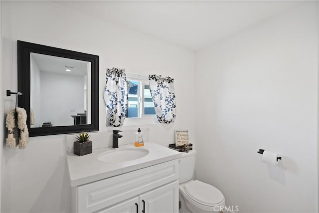 bathroom featuring vanity and toilet